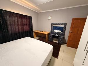 a bedroom with a bed and a computer on a desk at The Marina Suite in Mbabane