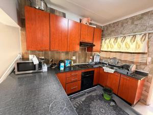 a kitchen with wooden cabinets and a microwave at The Marina Suite in Mbabane +9 photos
