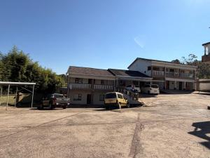 a parking lot with cars parked in front of a building at The Marina Suite in Mbabane