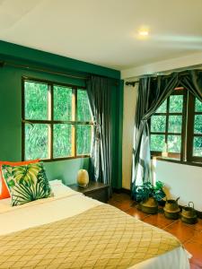 a bedroom with a bed and two windows at Nong Thale Garden in Ban Khao Klom +113 photos