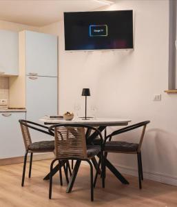 a dining room table with two chairs and a tv at Tiny Park House in Sabaudia