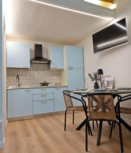a kitchen with blue cabinets and a table and chairs at Tiny Park House in Sabaudia