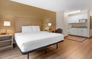 a bedroom with a large bed and a kitchen at Extended Stay America Suites - Fort Worth - Fossil Creek in Fort Worth