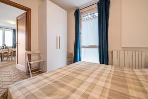 a bedroom with a bed and a dining room at Al Agave sotto in Toscolano Maderno