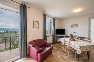 a living room with a table and a balcony at Al Agave sotto in Toscolano Maderno
