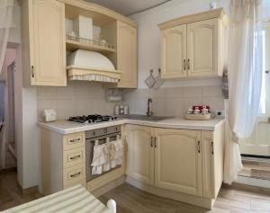 a kitchen with white cabinets and a stove at Le Stanze del Castello - Romantica in Ascoli Satriano