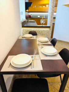 a dining table with white plates and glasses on it at Casa Matteo Piran in Piran