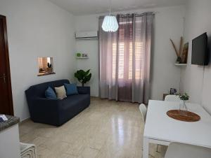 a living room with a blue couch and a table at Casa Melf in Terrasini