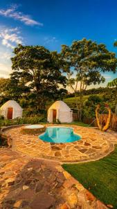 a backyard with a swimming pool and two tents at Aldea Ancestral by ID Hotel in Barbosa