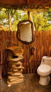 a bathroom with a toilet and a wooden fence at Aldea Ancestral by ID Hotel in Barbosa