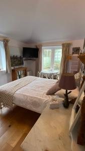 a bedroom with a bed and a table with a lamp at Exmoor retreat on Two Moors Way in Withypool