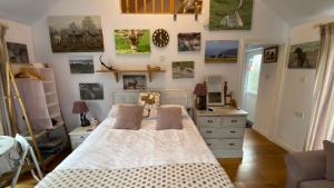 a bedroom with a bed and some pictures on the wall at Exmoor retreat on Two Moors Way in Withypool