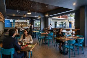 a group of people sitting at tables in a restaurant at Novapark in Santiago