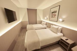 a hotel room with two beds and a flat screen tv at Novapark in Santiago