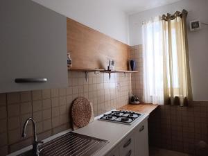 a small kitchen with a stove and a sink at Casa Melf in Terrasini