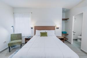 a bedroom with a large white bed and a chair at Casa Verde in Monterrey