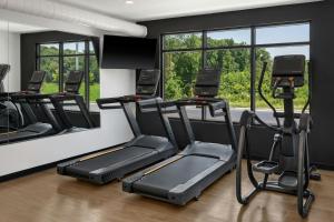 a gym with three treadmills and two mirrors at StudioRes by Marriott Greensboro Airport in Greensboro
