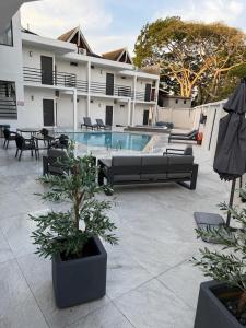 a courtyard with a pool and tables and chairs at Burapha hotel in Ban Ta Sang