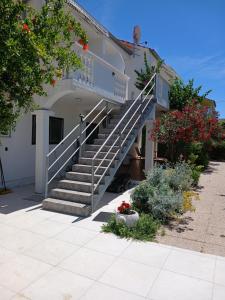 a building with a staircase on the side of it at Apartments Golić in Biograd na Moru