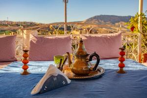 a table with a tea kettle and a napkin on it at Dar Iline - RoofTop in Fez