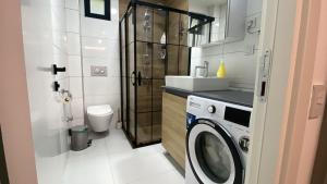 a small bathroom with a washing machine in it at Modern Garden House in Tivat +115 photos