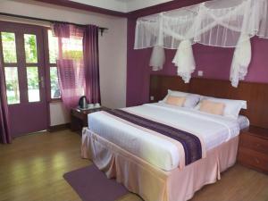 a bedroom with a large bed with purple walls at Destination Resort Centre in Gikuu +34 photos