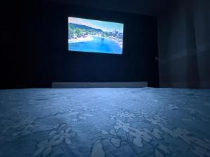 a bedroom with a bed with a tv on the wall at Apartmani Benjamin in Tuzla