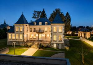 an estate with a large house at dusk at Domitys - Le Carillon d'or in Maubeuge