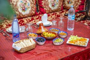 a table topped with bowls of food and bottles of water at Dar Iline - RoofTop in Fez +97 photos