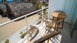 a balcony with a table and a chair and a table at qema Mancora in Máncora