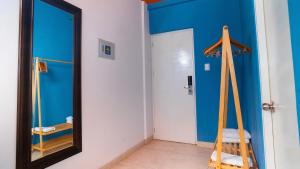a mirror in a bathroom with a blue wall at qema Mancora in Máncora