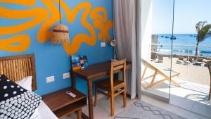 a bedroom with a desk and a view of the beach at qema Mancora in Máncora +51 photos