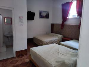 a small room with two beds and a sink at Santa Beatriz in Lima