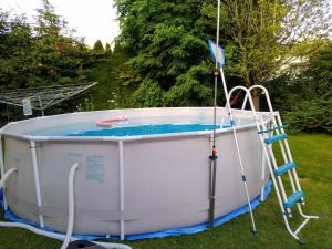 a hot tub with a ladder in a yard at Chambre ravissante, piscine et confort d'une maison in Les Bois