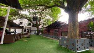 a green yard with a tree in front of a building at Novatel Radisson Lekki in Lekki
