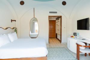 a bedroom with a bed and a desk and a mirror at Diamond Beach By Pearl Resort in Quseir