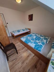 a bedroom with two beds and a chair in it at Chalupa u Strakov in Lúčky