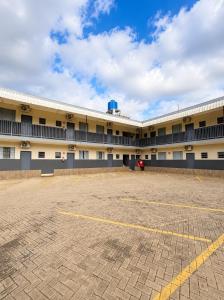 an empty parking lot in front of a large building at Glória Hotel in Olímpia