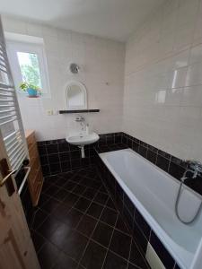 a bathroom with a white tub and a sink at Chalupa u Strakov in Lúčky
