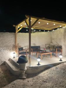 a pavilion with benches and lights in the sand at night at Petite maison plain-pied climatisé in Migné-Auxances