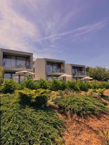 a building on top of a hill with bushes at Zambujal Suites in Sesimbra