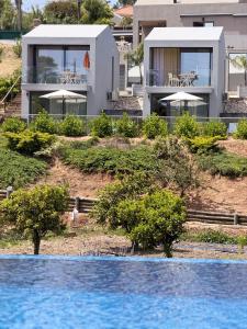 a house on a hill with a swimming pool at Zambujal Suites in Sesimbra