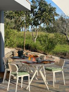 a table with chairs and fruit on a patio at Zambujal Suites in Sesimbra