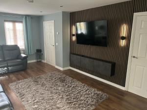 a living room with a couch and a television on a wall at Daves Cave in Antrim