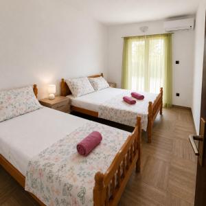 a bedroom with two beds with red pillows on them at Croatia Apartman Masa in Senj