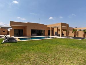 a house with a swimming pool in front of a yard at Villa Inaya in Tasdert