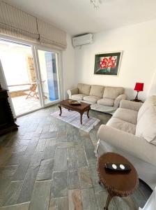 a living room with a couch and a table at Aegean Big Blue -Rosalie Home in Tinos