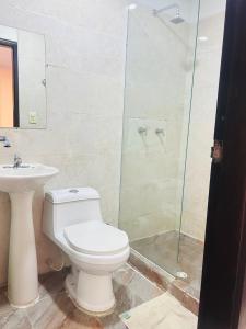 a bathroom with a toilet and a glass shower at Hotel Galeria la Trinidad in Cartagena de Indias +52 photos