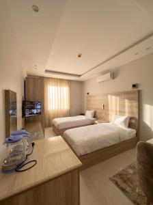 a hotel room with two beds and a television at Elite hotel in Sheikh Zayed