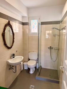 a bathroom with a toilet and a sink and a shower at Aegean Big Blue -Rosalie Home in Tinos +11 photos